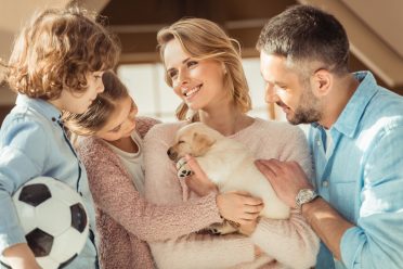 a Labrador puppy with its new owners or family